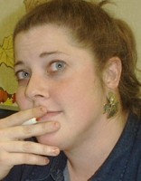 Kathy Silverman Red-haired woman holding a pen and looking pensive